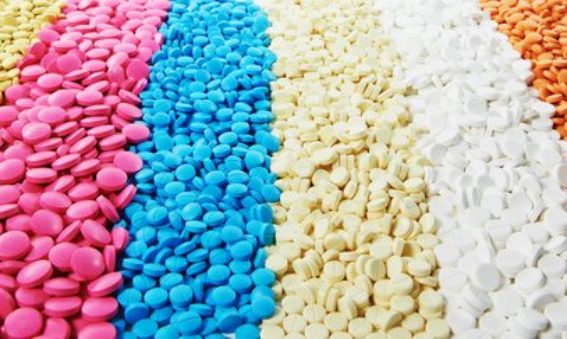 A pile of antibiotic pills in different colours.