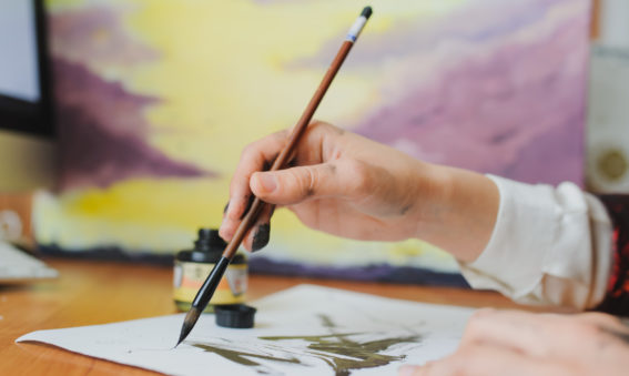 A hand writing chinese calligraphy with ink.