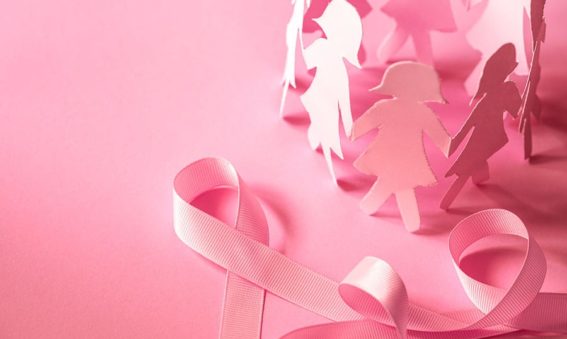 Pink cut outs of women in paper with a pink ribbon on a pink background